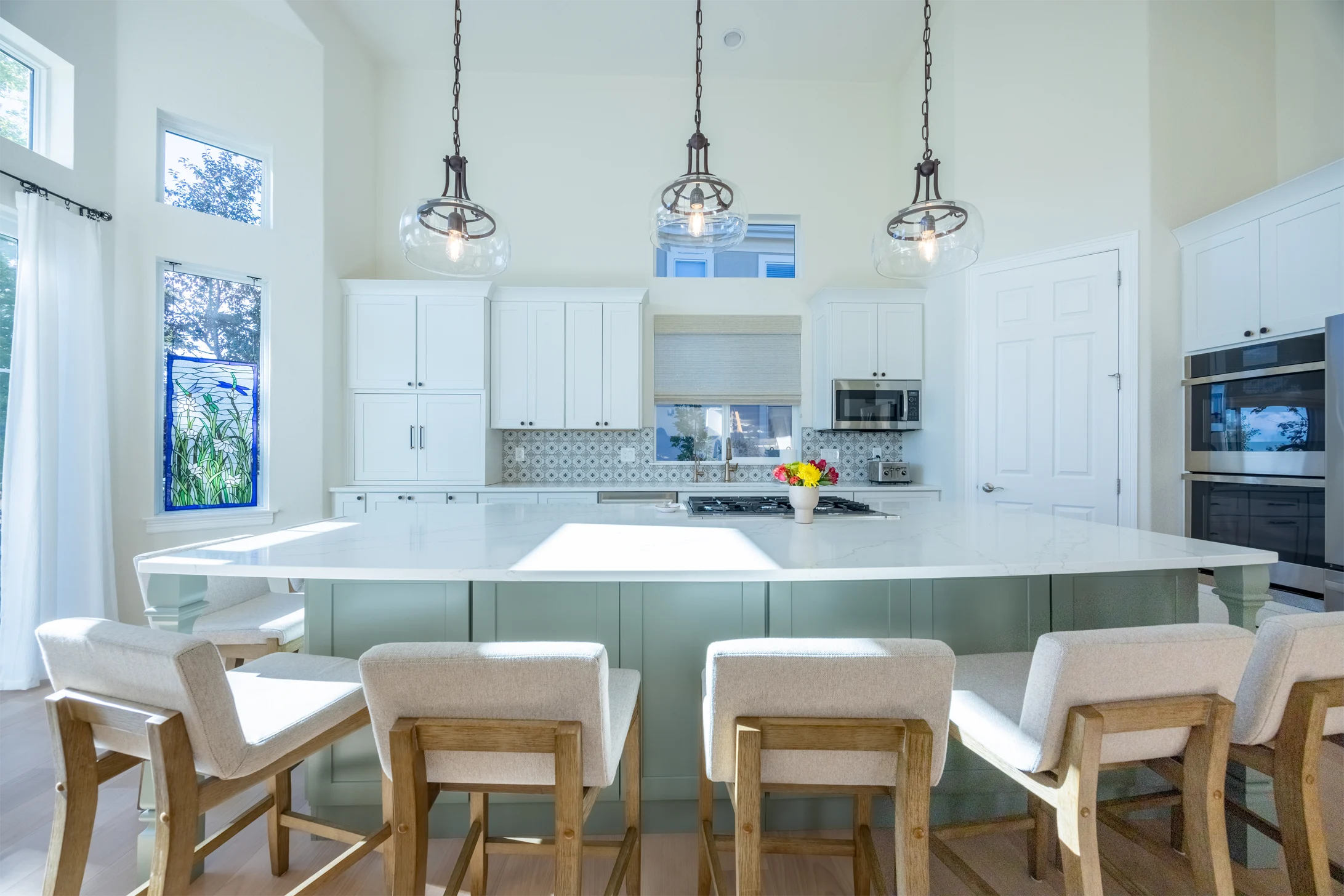 Light-filled Rosedale kitchen with white cabinetry and a pale green island