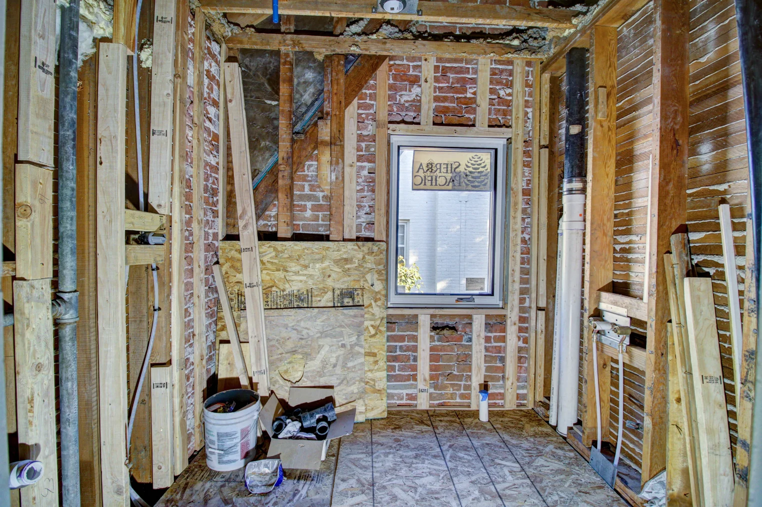 Queens Village bathroom during demolition with exposed framing and plumbing