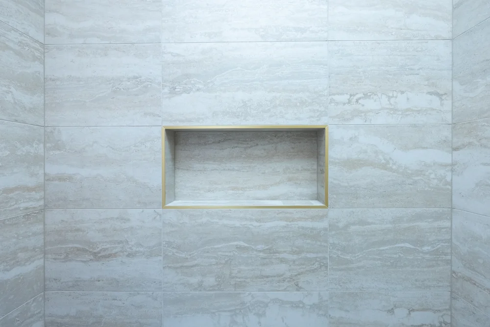 Gold-trimmed shower niche in the remodeled children’s bathroom